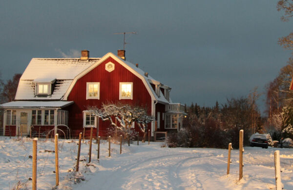 Rött hus vid vintrig landsväg