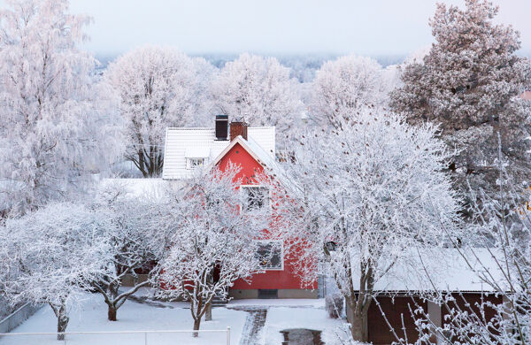 Rött hus i vinterlandskap 