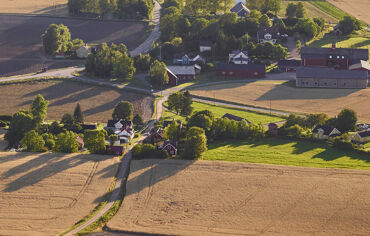 Flygbild över åkerlandskap med gårdsboende och lantbruk
