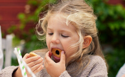 Flicka som äter kaka utomhus