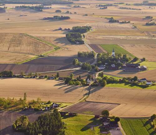 Flygfoto över landskap med åkrar och kyrka