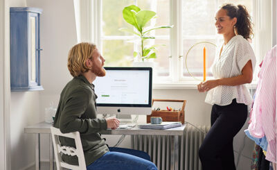 Man och kvinna som pratar vid en dator i hemmet