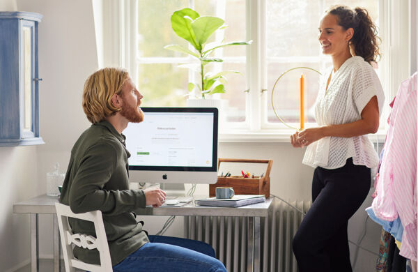 Man och kvinna som pratar vid en dator i hemmet