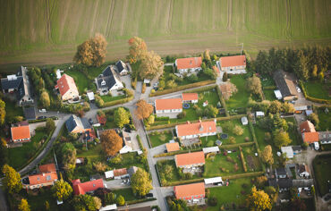 Flygfoto över villakvarter bredvid åker