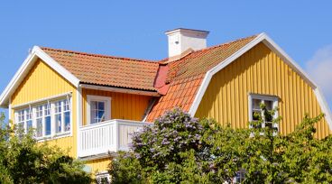 Övre delen av en gul villa mot blå himmel