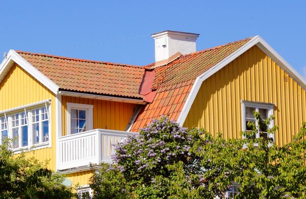 Övre delen av en gul villa mot blå himmel